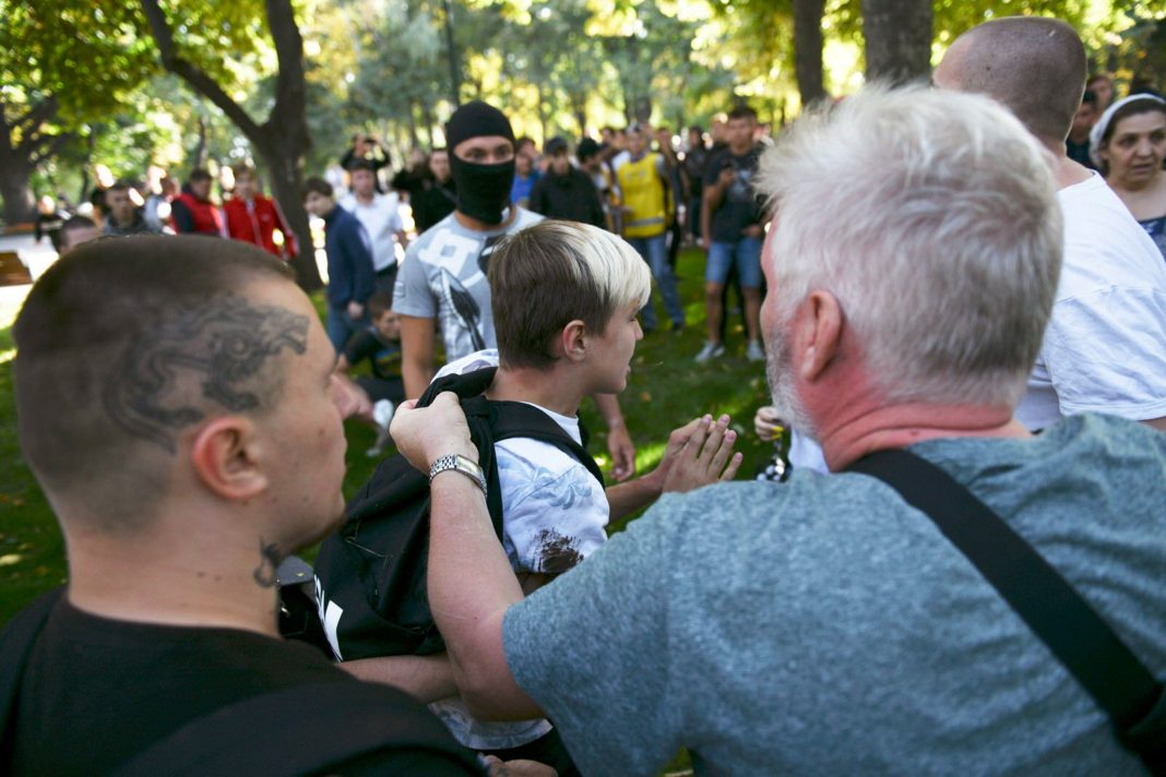 Гаранич (справа) за рюкзак вытаскивает юношу, участника движения, из рук мужчины с татуировкой на голове (слева). Фото Андрея Кравченко. Фото Андрея Кравченко.